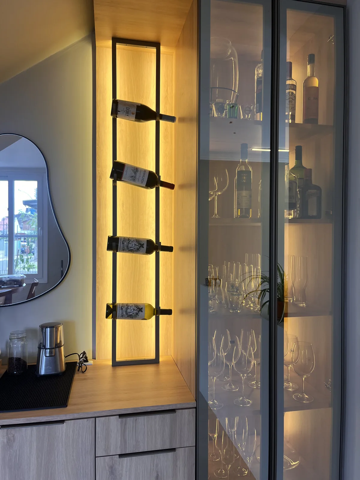 Adega vertical iluminada com cristaleira de vidro e bancada amadeirada